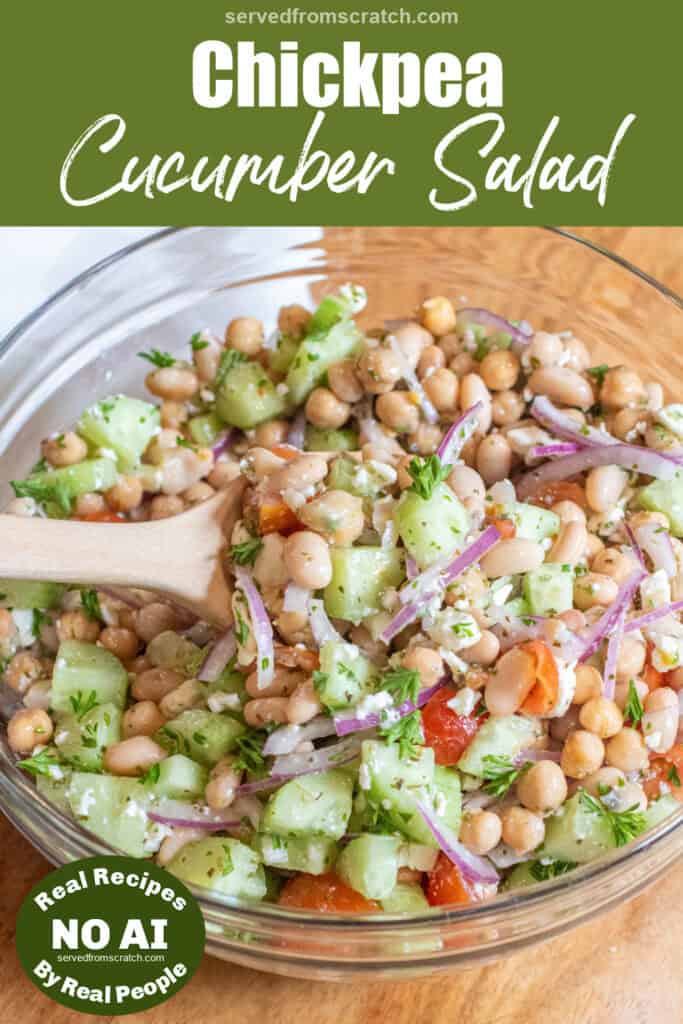 a bowl of chickpeas, beans, cucumber, tomatoes, onions, and feta with a spoonful in a wooden spoon with Pinterest pin text and NO AI sticker.