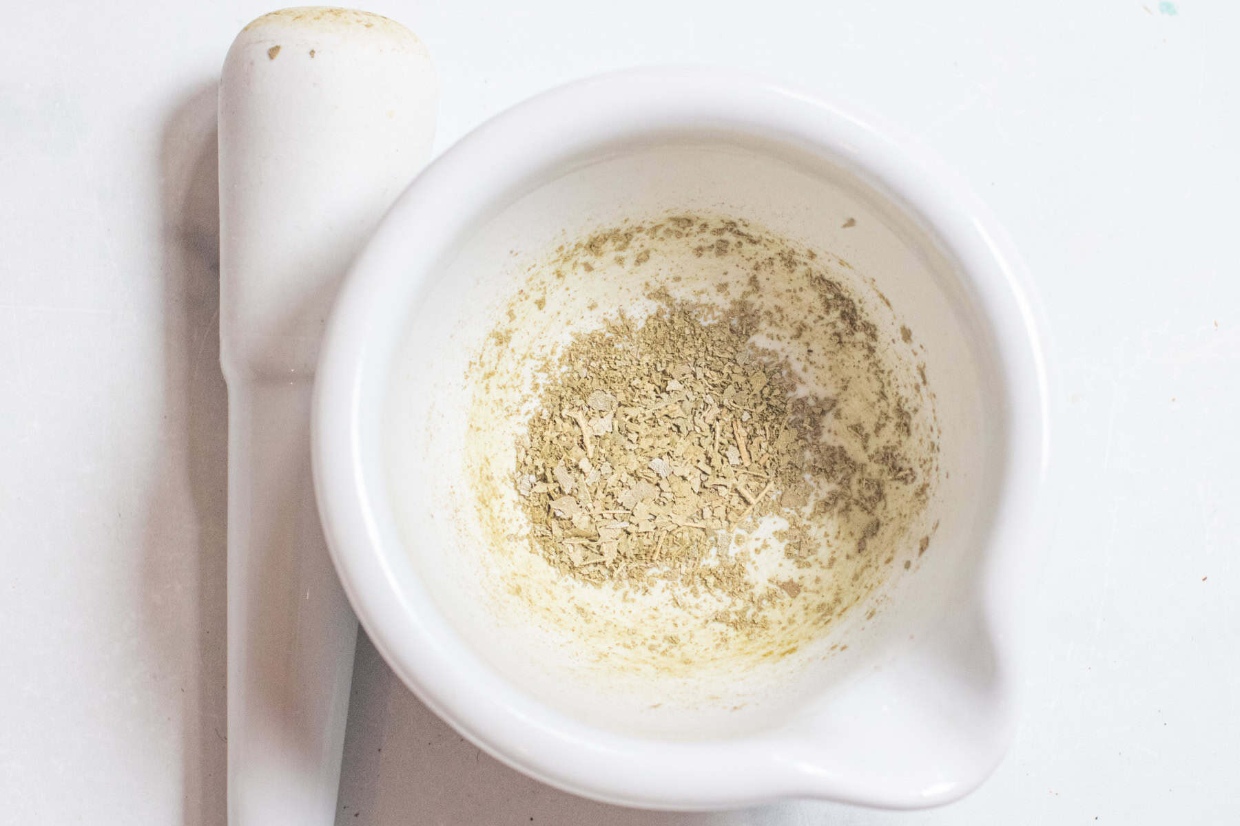 a mortar and pestle with ground bay leaves.