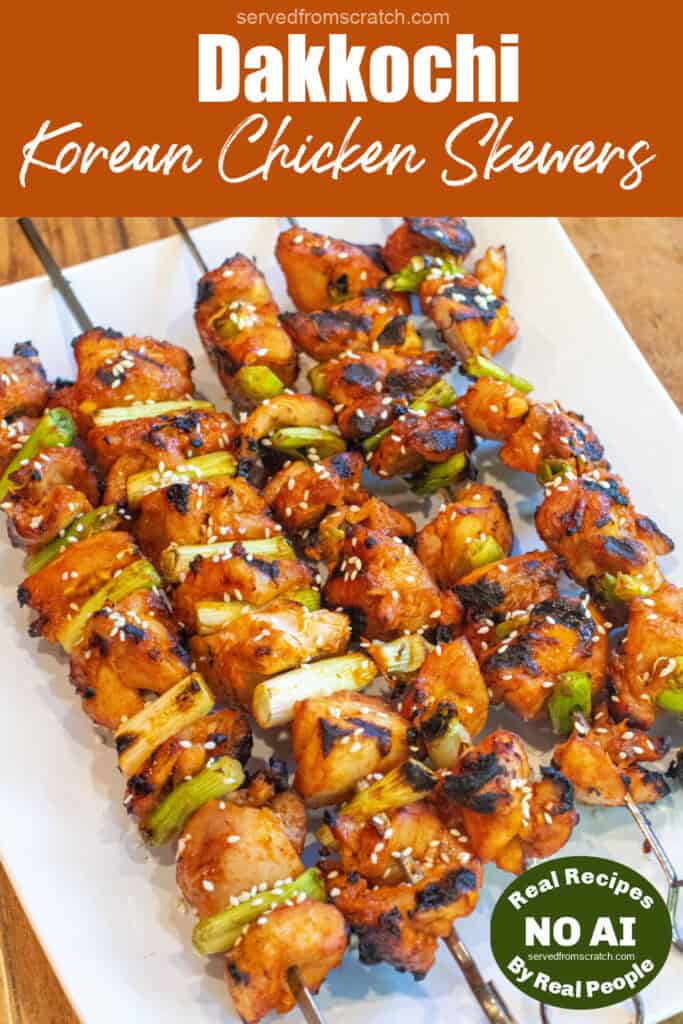 a large plate of grilled chicken skewers with green onion and sesame seeds with Pinterest pin text and NO AI sticker.