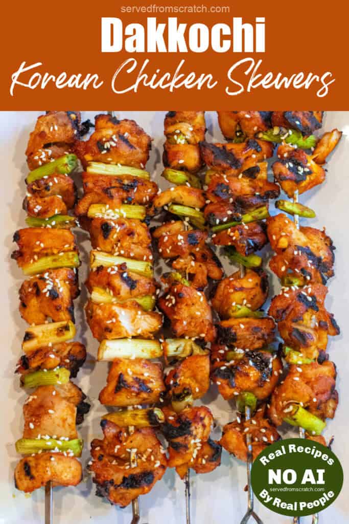 a large plate of grilled chicken skewers with green onion and sesame seeds with Pinterest pin text and NO AI sticker.