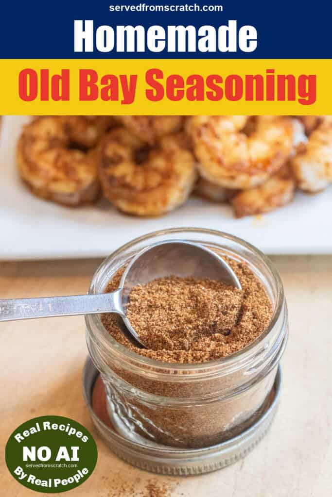 a small mason jar with a spoon and a seasoning mix in front of a plate of cooked seasoned shrimp with Pinterest pin text and no AI Sticker.