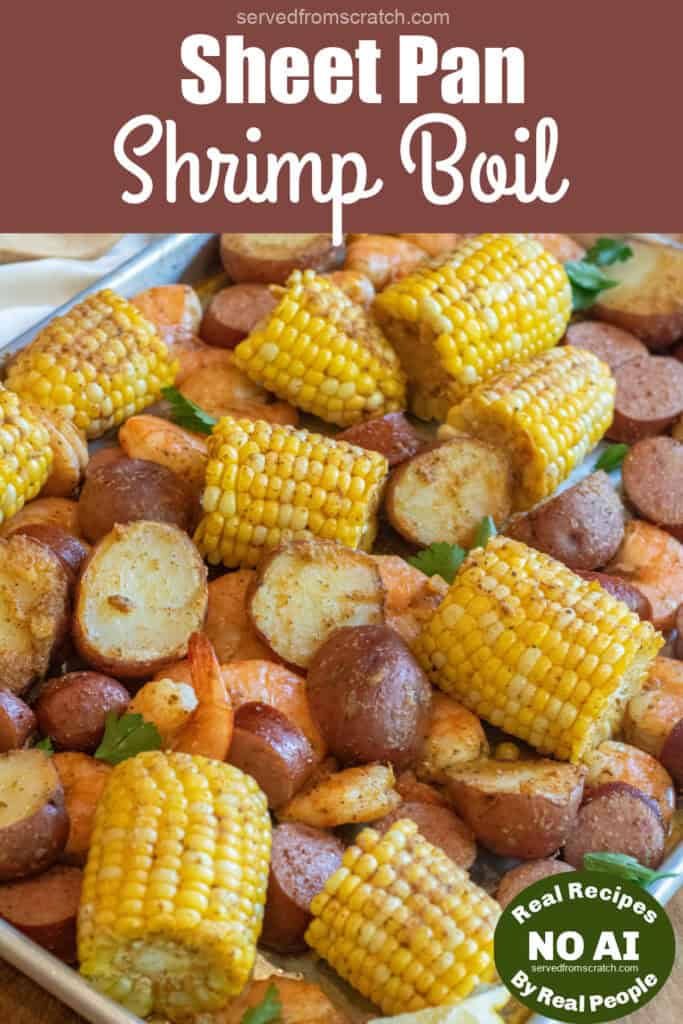 an overhead of a sheet pan with cooked corn on the cob pieces, shrimp, and potatoes with Pinterest pin text and NO AI sticker.