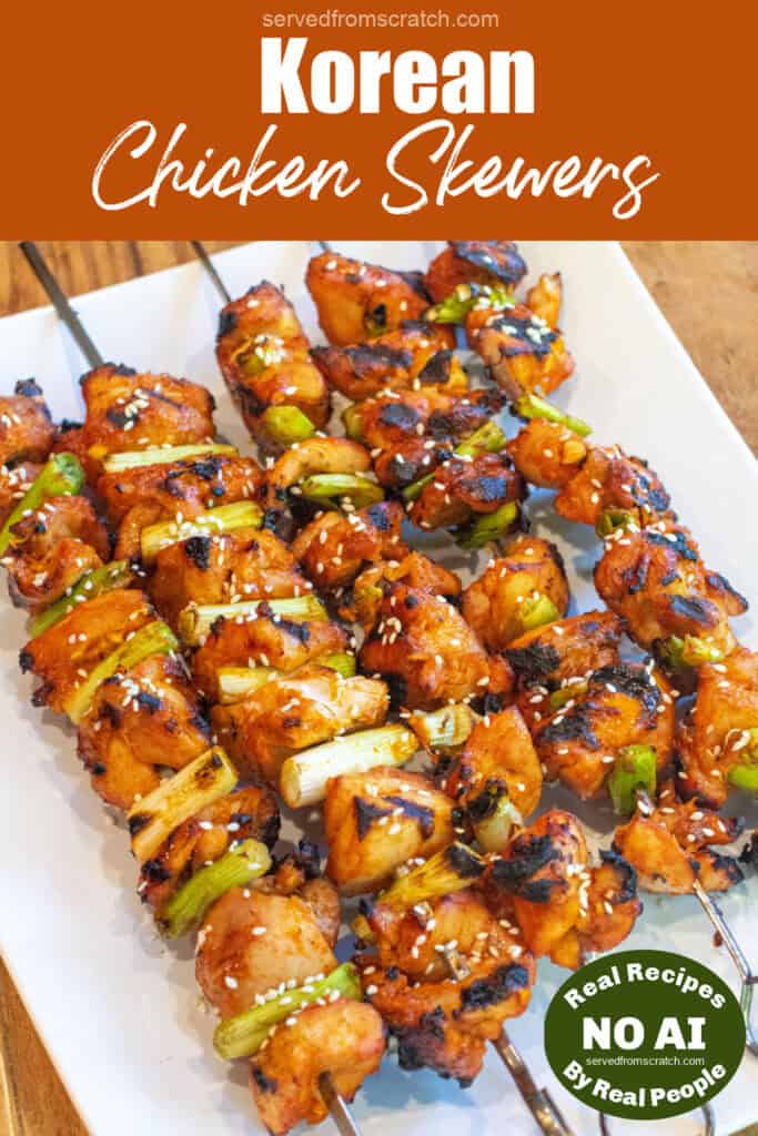 a large plate of grilled chicken skewers with green onion and sesame seeds with Pinterest pin text and NO AI sticker.
