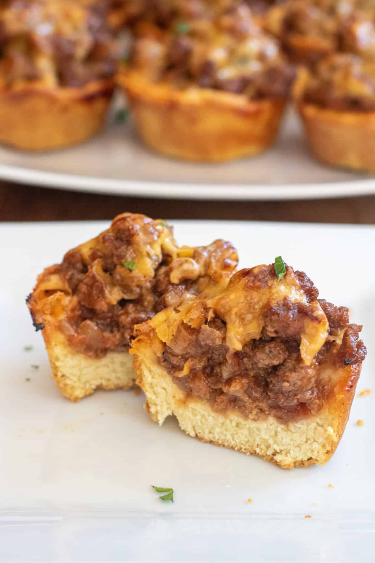a plate with two cups of cooked ground beef and cheese halved.