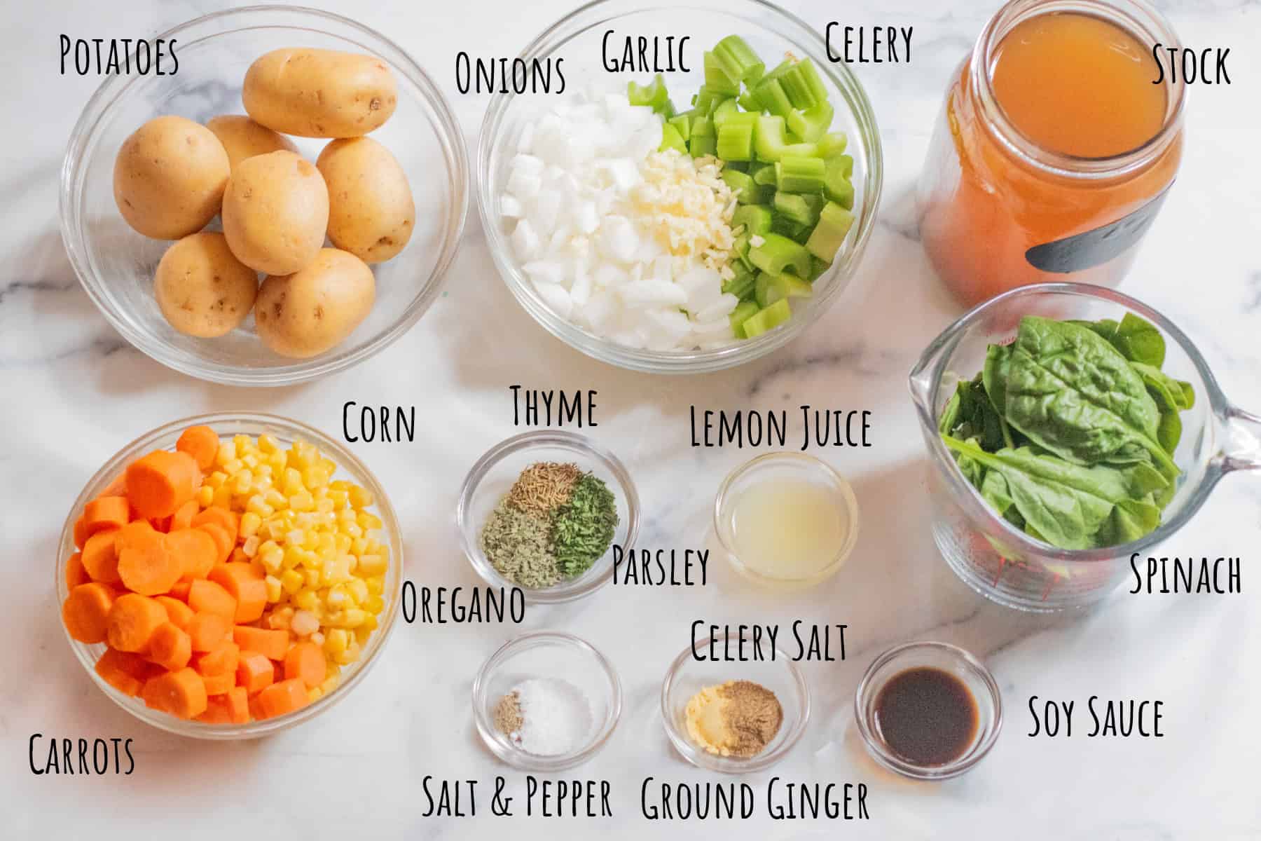 bowls of potatoes, diced onion, celery, garlic, carrots, corn, spices, spinach, soy sauce, and a jar of stock, all labeled.