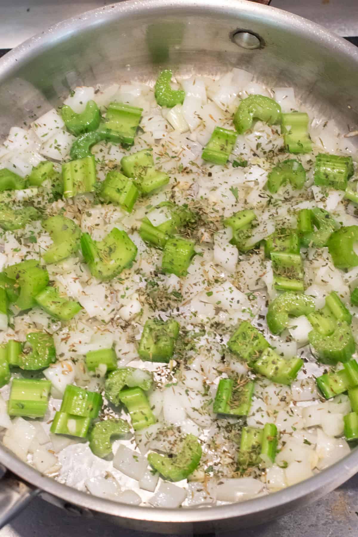a saute pan with onion, celery, and herbs.