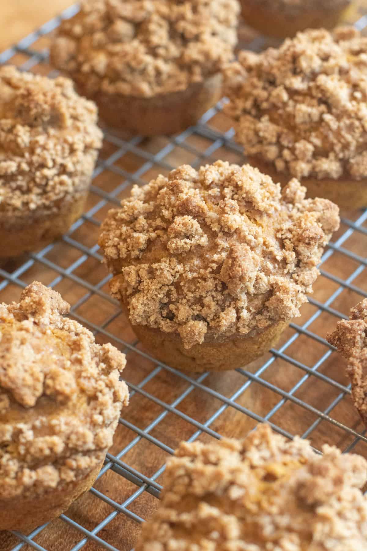 a cooling rack of muffins with a crumble topping.