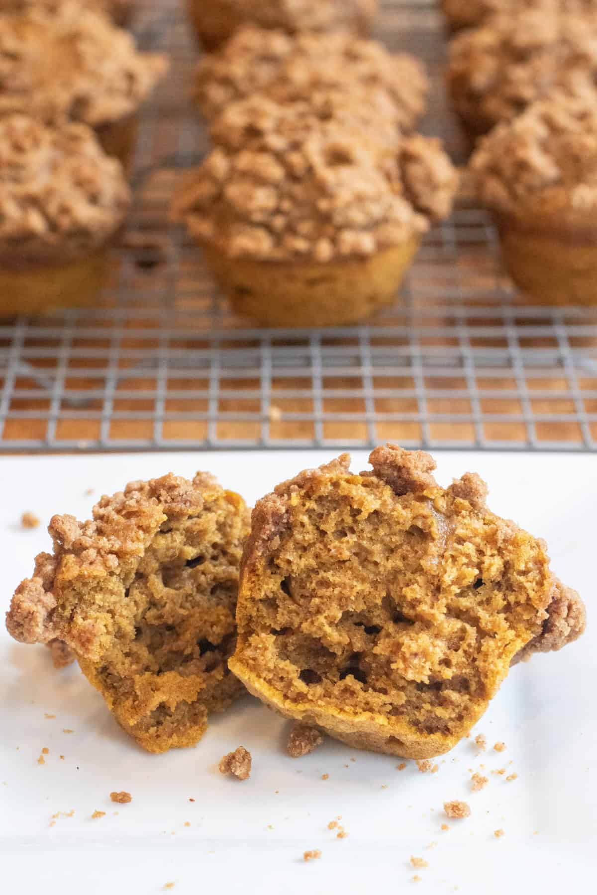 a halved muffin on a plate with a crumble topping.