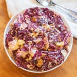 an overhead of a bowl of radicchio salad with dressing and croutons.