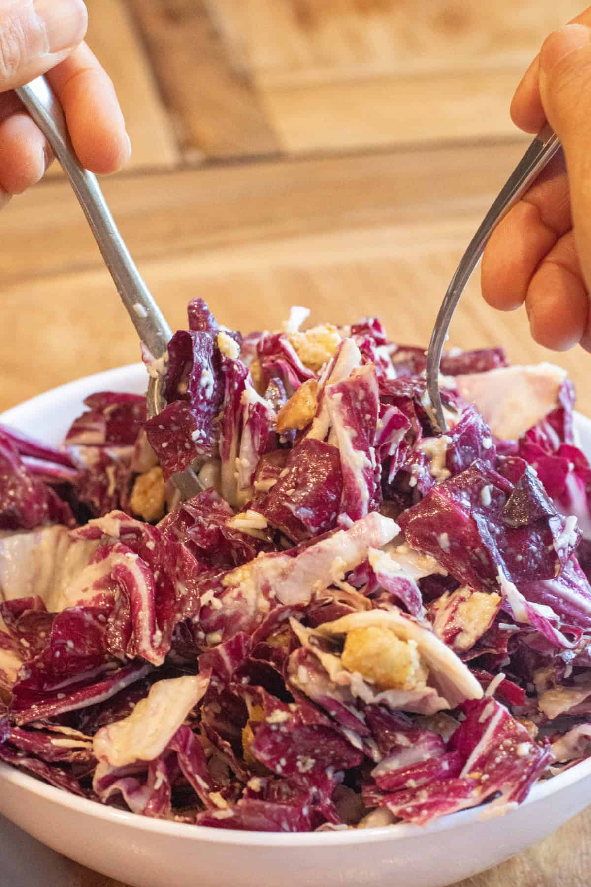 two forks holding up some creamy radicchio salad.